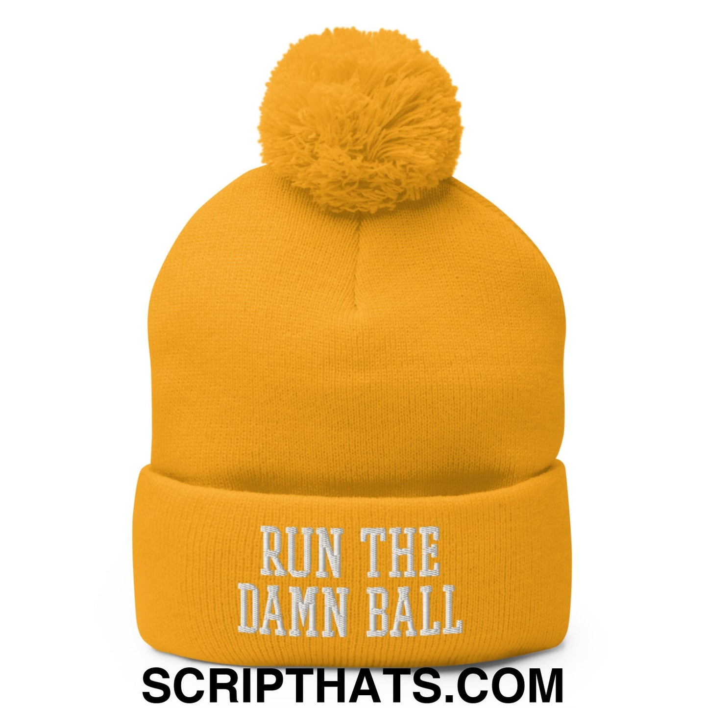A vibrant yellow knit beanie with a fluffy pom pom and white run the damn ball embroidered text on the cuff