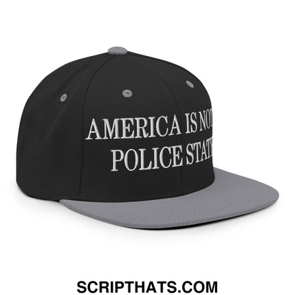 Black snapback cap with gray brim and white embroidered text america is not a police state flat bill hat