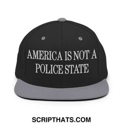 Black snapback cap with gray brim and white embroidered america is not a police state text on front