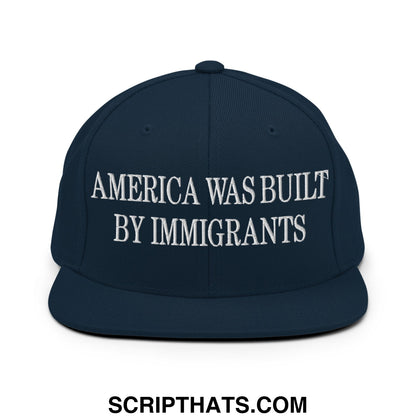 Navy blue snapback hat with white embroidered america was built by immigrants text and flat bill brim design