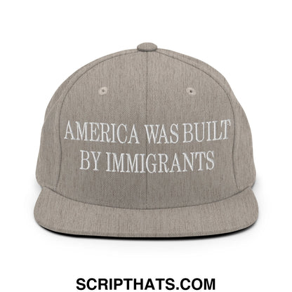 Gray flat bill snapback hat with white embroidered america was built by immigrants text across the front