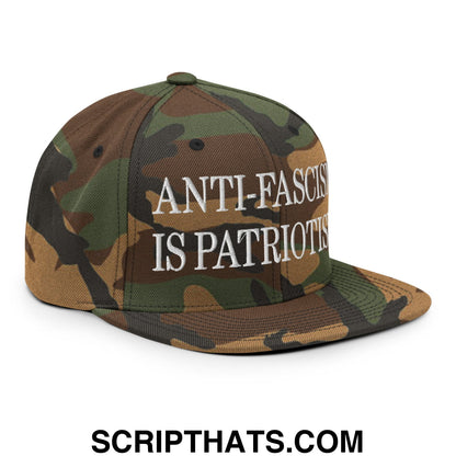 A camouflage snapback hat with white embroidered anti-fascism is patriotism text and a flat bill brim