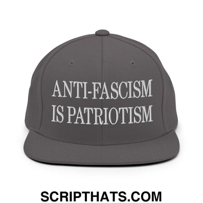 Gray snapback hat with white embroidered text anti-fascism is patriotism on flat bill brim for casual wear