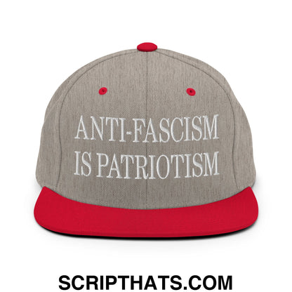 Gray snapback cap with red brim and button featuring white embroidered text anti-fascism is patriotism