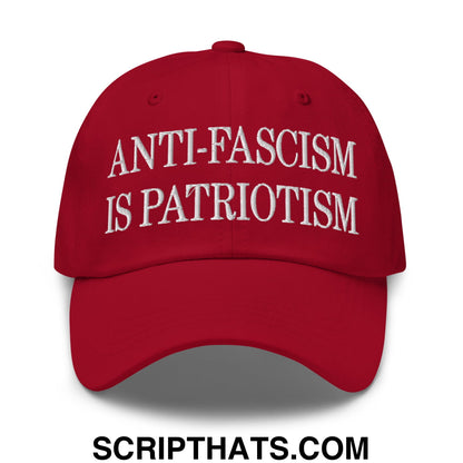 Red unstructured dad hat with white embroidered text anti-fascism is patriotism made of cotton blend
