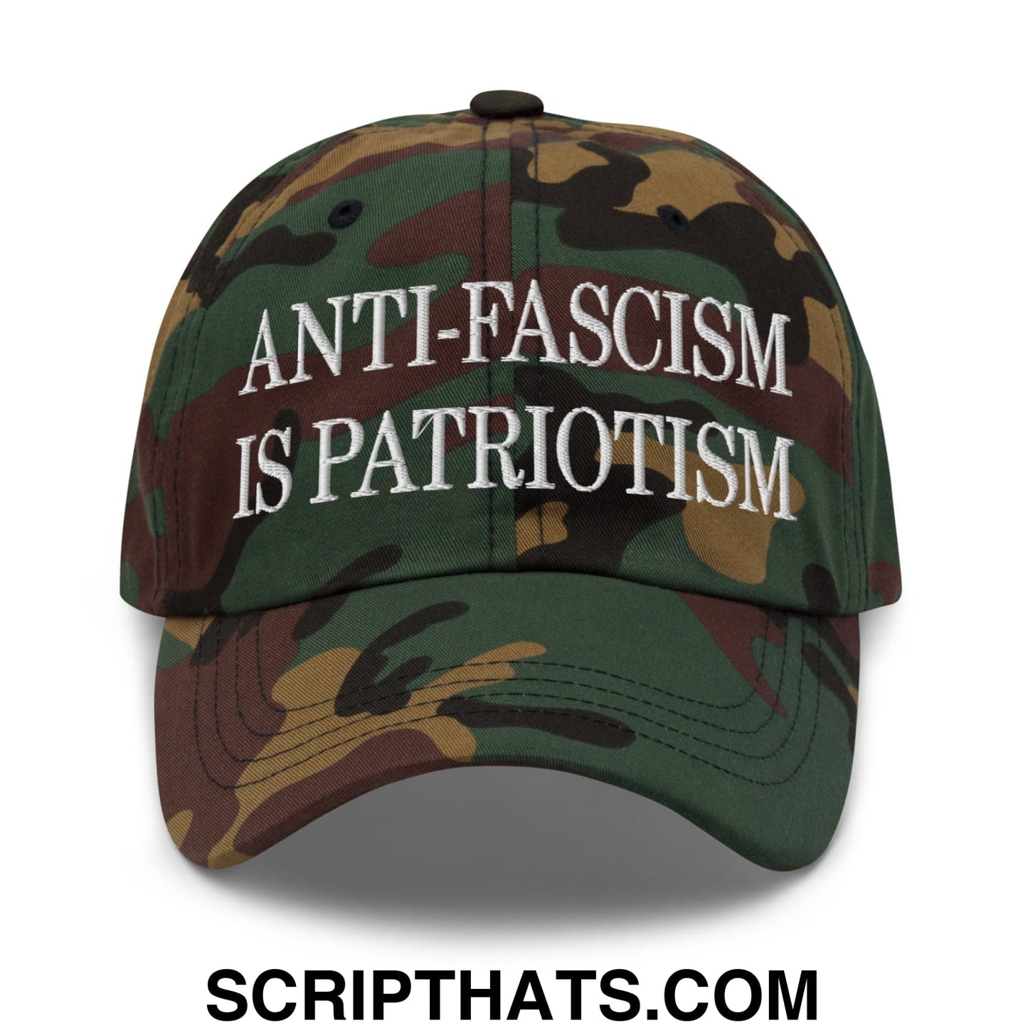 A camouflage unstructured dad hat with white embroidered text reading anti-fascism is patriotism