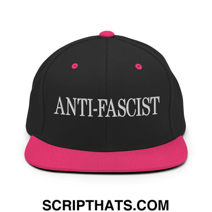 Black snapback cap with vibrant pink brim and button embroidered with anti-fascist in bold white lettering