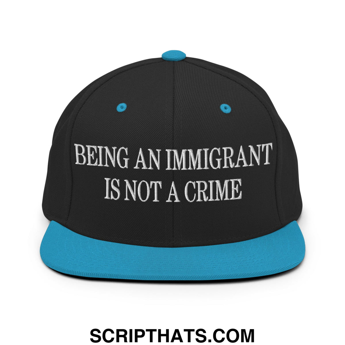 Black snapback hat with teal brim and button featuring white embroidered text being an immigrant is not a crime