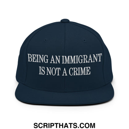 Navy blue snapback hat with white embroidered text being an immigrant is not a crime flat bill brim design