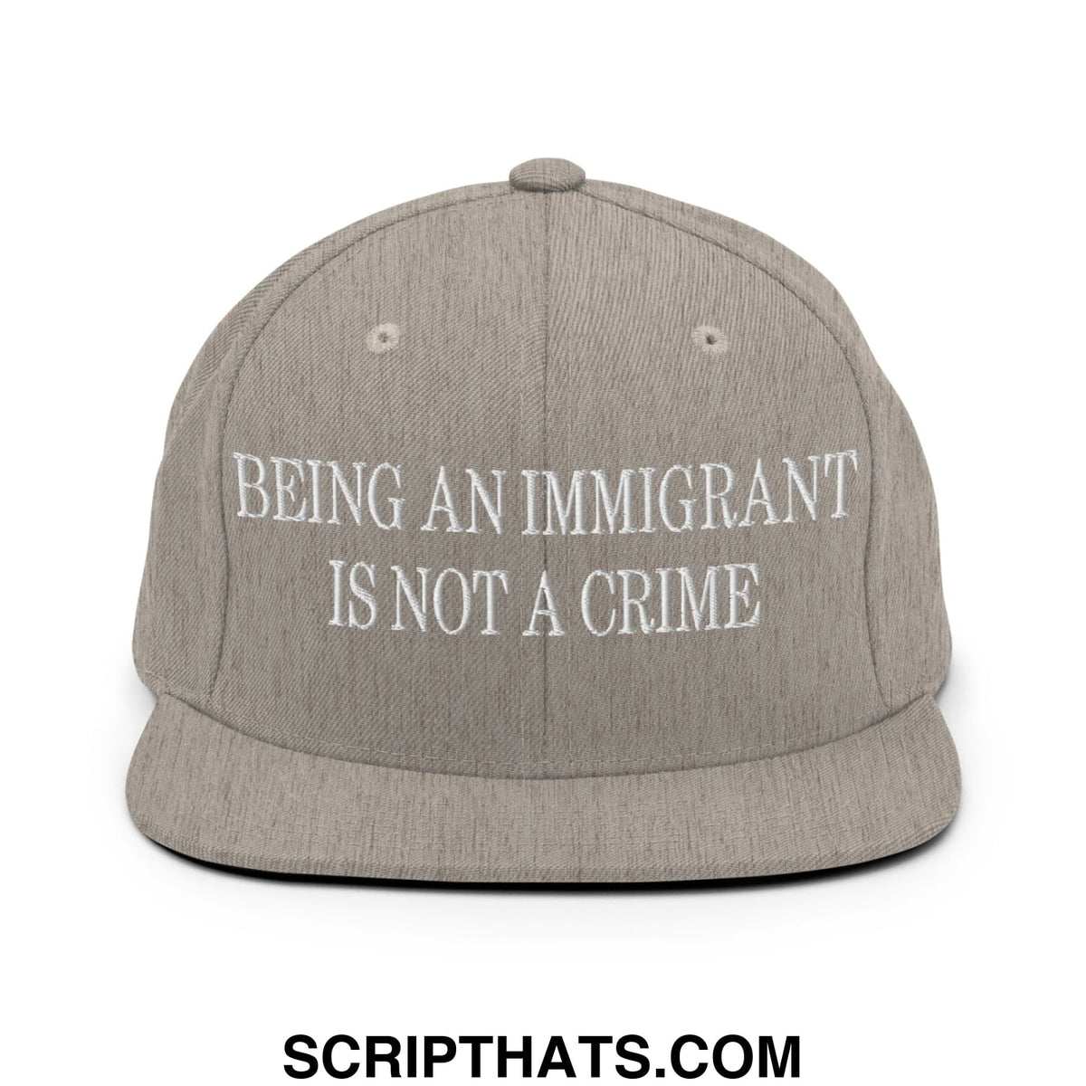 Gray snapback hat with white embroidered text being an immigrant is not a crime on flat bill brim