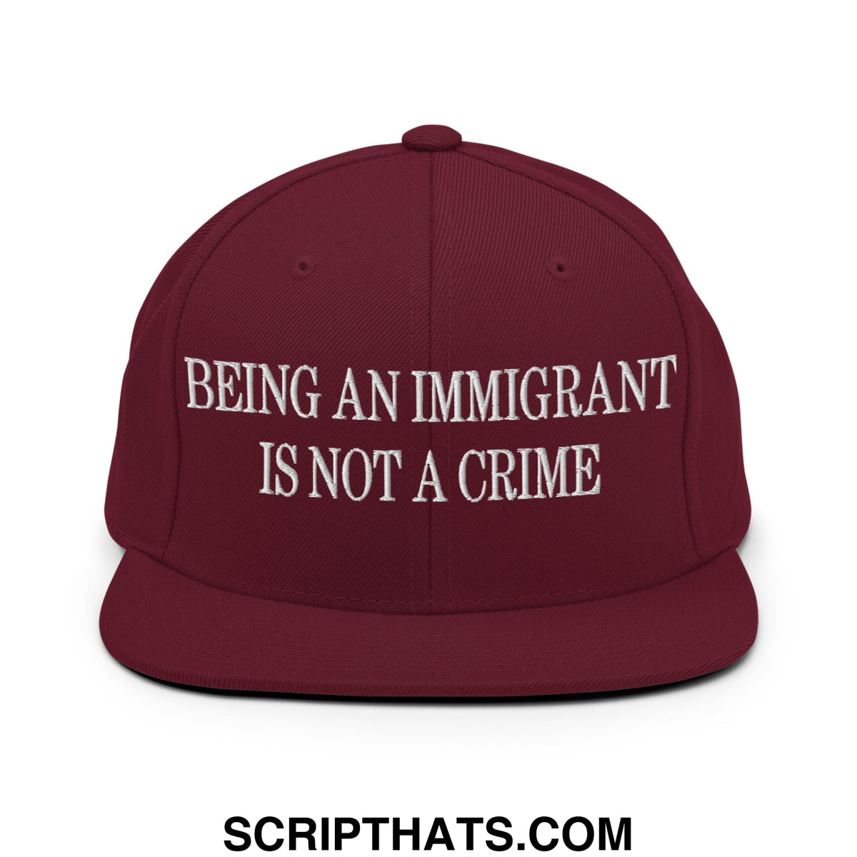 Maroon flat bill brim snapback hat with white embroidered text being an immigrant is not a crime