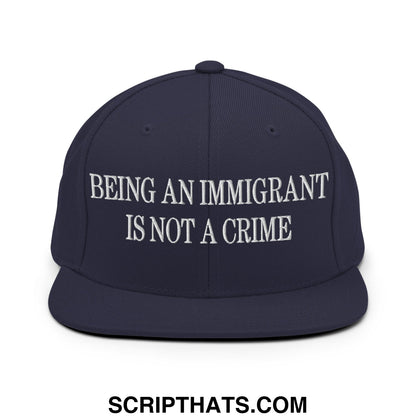 Navy blue snapback hat with white embroidered being an immigrant is not a crime text and flat bill brim design
