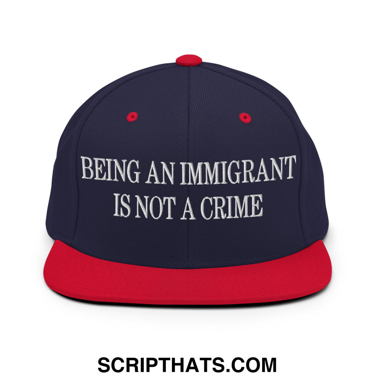 Navy blue and red snapback hat with white embroidered text being an immigrant is not a crime on flat bill brim