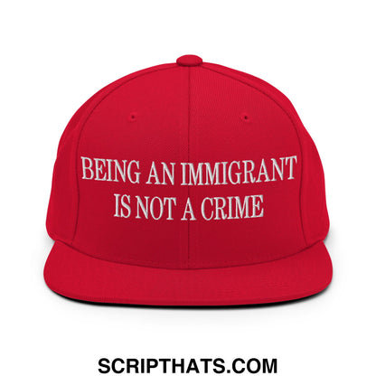Red snapback hat with white embroidered being an immigrant is not a crime text and flat bill brim design