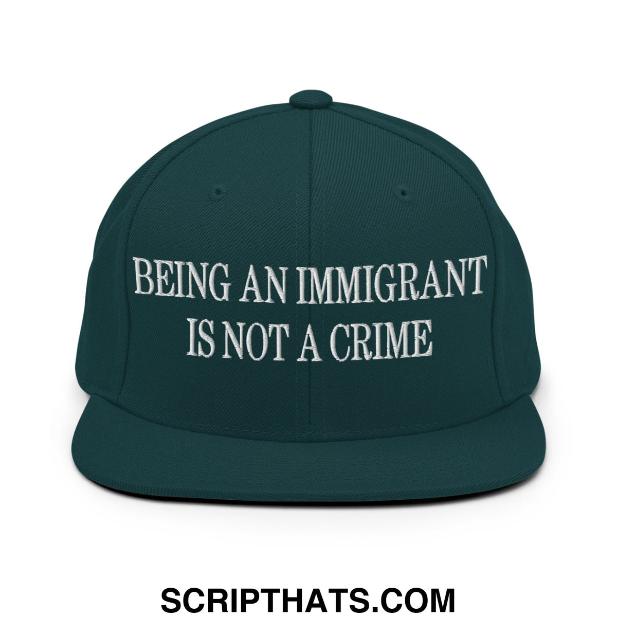 Dark green snapback hat with white embroidered text being an immigrant is not a crime on flat bill brim