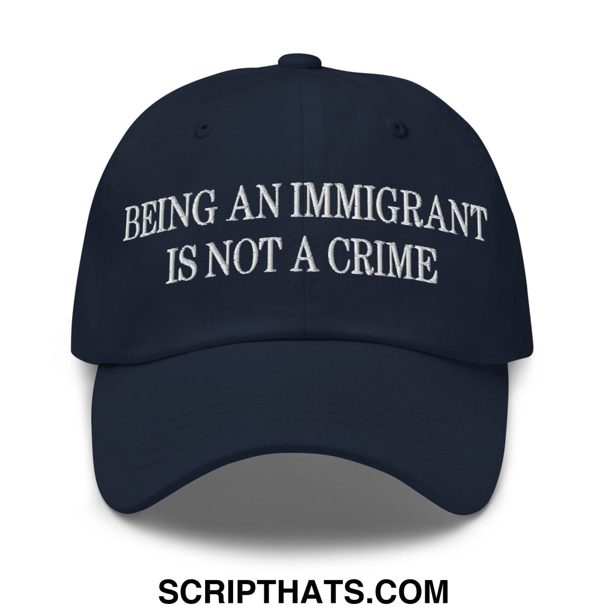 Navy blue embroidered unstructured dad hat with white stitched text being an immigrant is not a crime