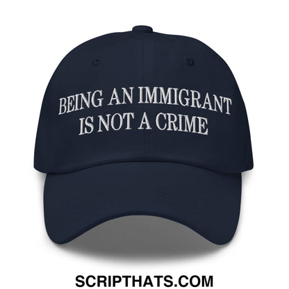 Navy blue embroidered unstructured dad hat with white stitched text being an immigrant is not a crime