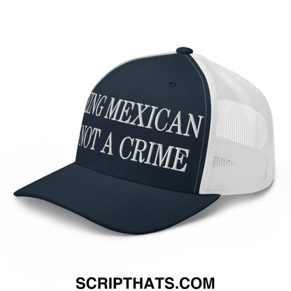 Navy blue and white mesh trucker hat with embroidered being mexican is not a crime text in bold uppercase letters