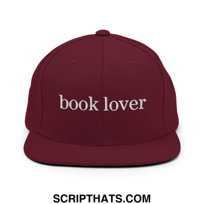 Maroon snapback cap with white embroidered book lover text and flat bill brim for casual wear