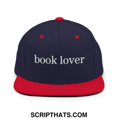Navy blue and red snapback hat with white embroidered book lover text and flat bill brim for casual wear