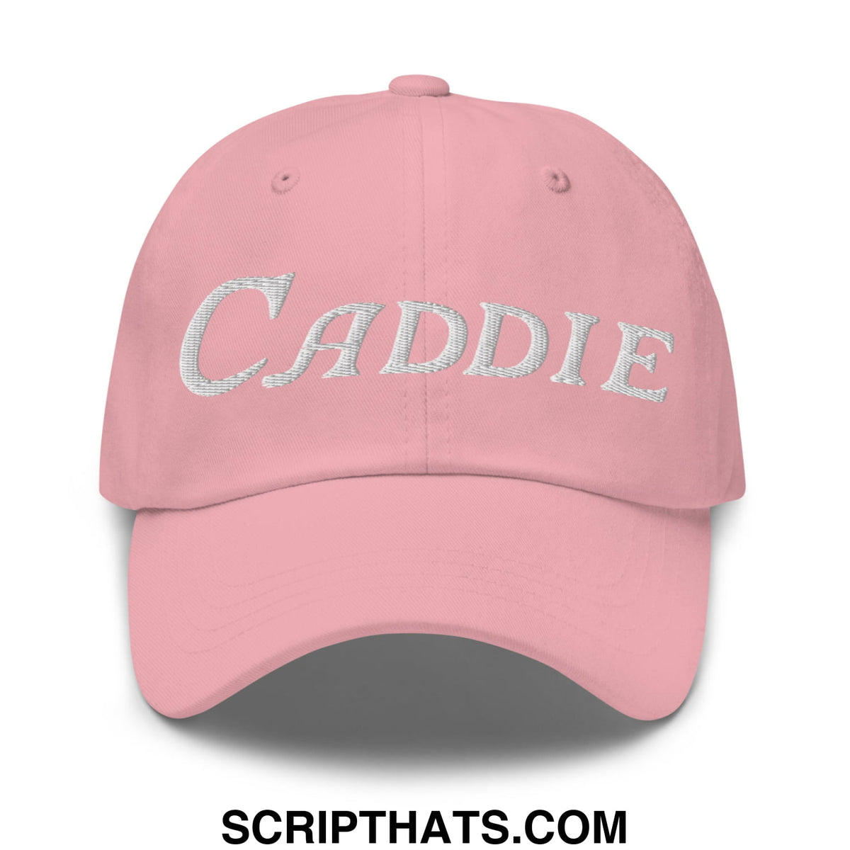 A soft pink unstructured golf dad hat with caddie embroidered in textured silver script on the front