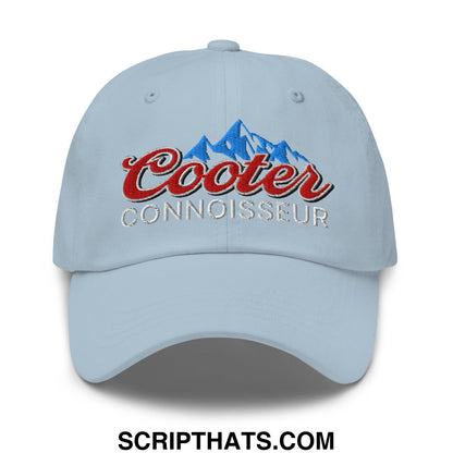 Light blue unstructured dad hat with embroidered cooter connoisseur logo in red and silver above a blue mountain design