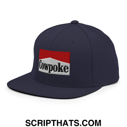 Navy blue snapback cap with flat bill brim featuring red and white embroidered cowpoke logo and black lettering