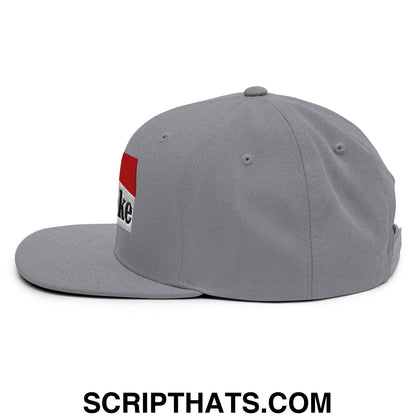 Gray cowpoke snapback hat with flat bill brim and red white patch featuring black embroidered text on the side