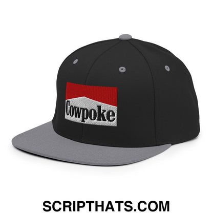 Black and gray snapback cap with red and white embroidered cowpoke logo on flat bill brim