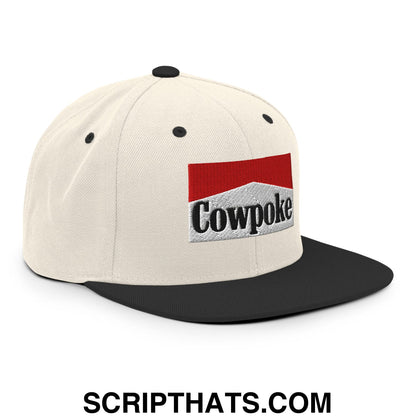 Cream-colored snapback hat with black flat bill brim and embroidered cowpoke logo on red and white patch