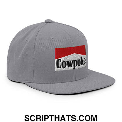 Gray snapback cap with a red and white embroidered cowpoke logo and black lettering on a flat bill brim