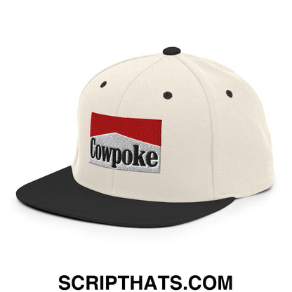 Cream-colored snapback cap with black brim and embroidered cowpoke logo in red white and gray colors