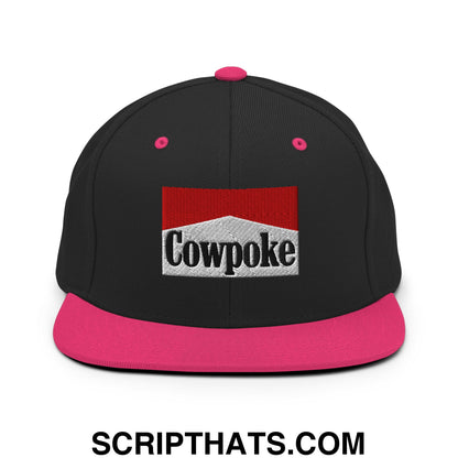 Black snapback cap with vibrant pink flat bill brim and button, embroidered cowpoke logo on silver textured background