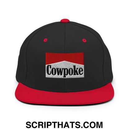 Black snapback cap with flat red brim and embroidered cowpoke logo on white textured patch in red frame