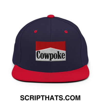 Navy blue and red snapback hat with white embroidered cowpoke logo and flat bill brim for casual wear