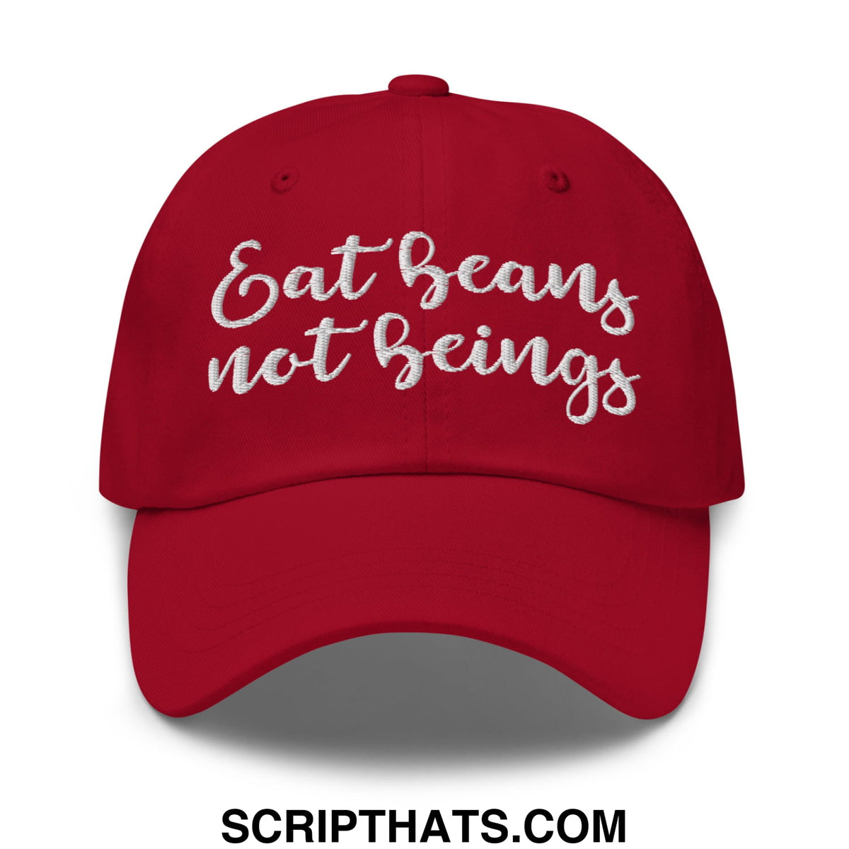 A vibrant red embroidered unstructured dad hat with white cursive text eat beans not beings on the front