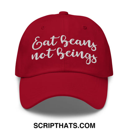 A vibrant red embroidered unstructured dad hat with white cursive text eat beans not beings on the front