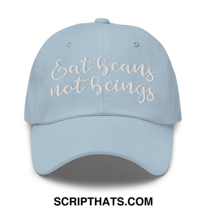 A light blue embroidered unstructured dad hat with the phrase eat beans not beings in white cursive thread