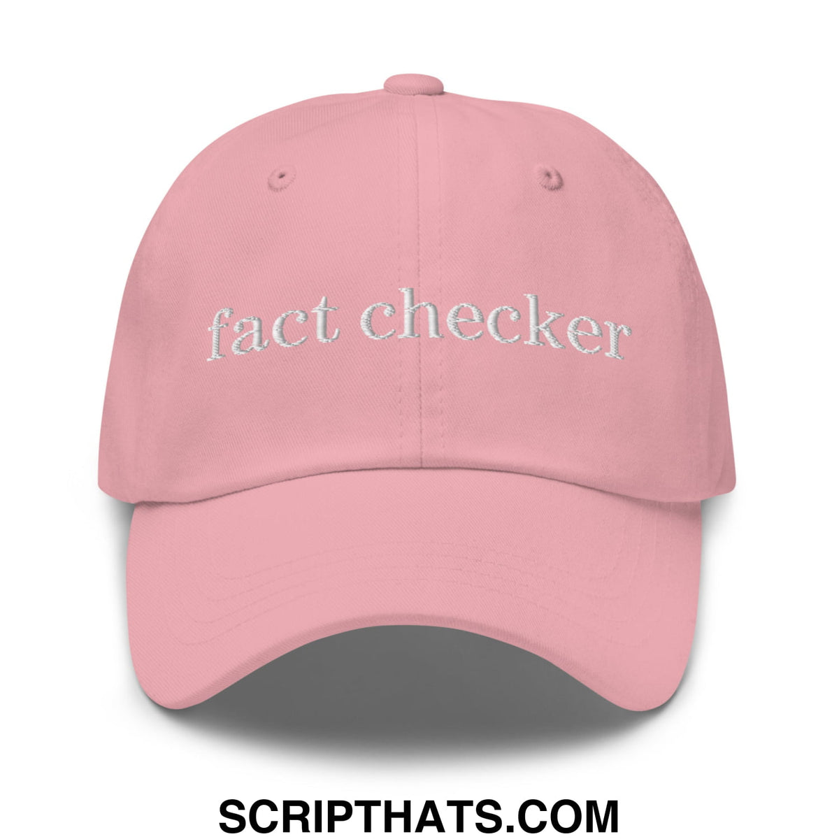 A soft pink fact checker embroidered unstructured dad hat with white thread lettering across the front panel