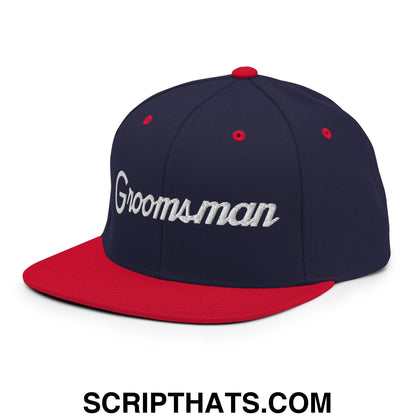 Navy blue and red snapback hat with white embroidered groomsman script and flat bill brim for wedding use