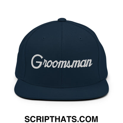 Navy blue snapback hat with white embroidered groomsman script and flat bill brim for wedding party use