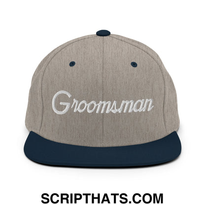 A gray and navy blue snapback cap with groomsman embroidered in white script on the front flat bill brim hat