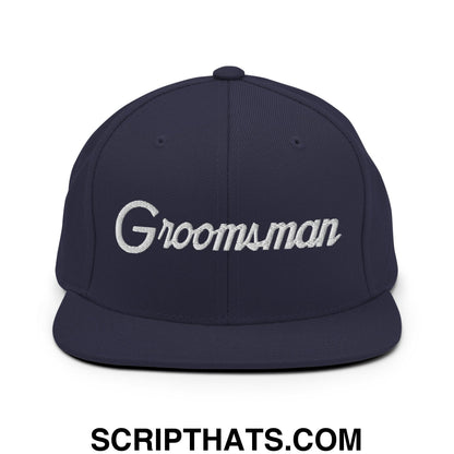 Navy blue snapback hat with white embroidered groomsman script and flat bill brim for wedding use