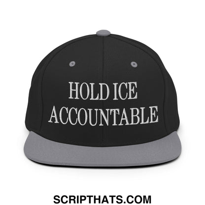 Black snapback cap with gray brim and embroidered white text hold ice accountable on front flat bill brim design