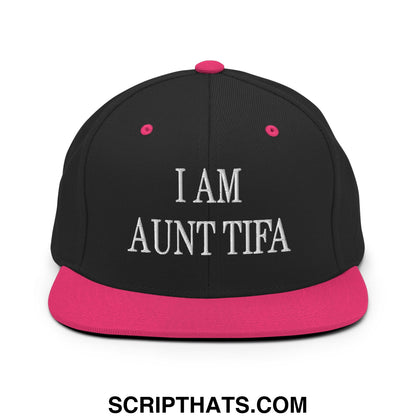 Black snapback cap with pink brim and button featuring white embroidered i am aunt tifa text on front