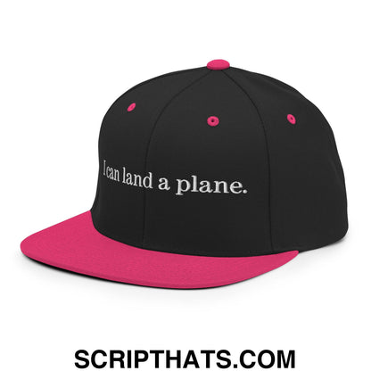 Black snapback cap with vibrant pink brim and button featuring white embroidered i can land a plane text