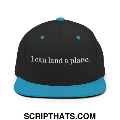 Black snapback cap with teal brim and button featuring white embroidered text i can land a plane flat bill brim hat