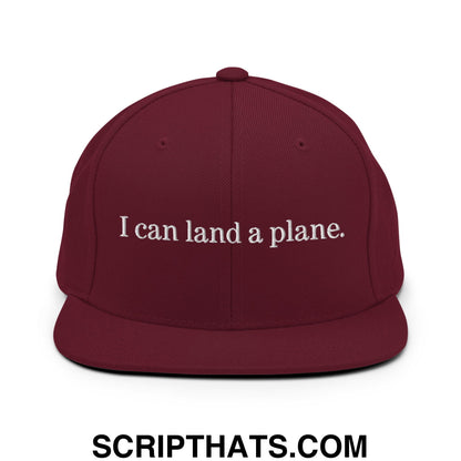 Maroon snapback hat with white embroidered text i can land a plane on a flat bill brim perfect for casual wear