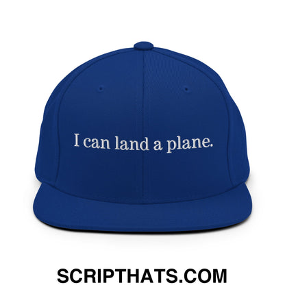 Royal blue snapback cap with white embroidered i can land a plane text featuring a flat bill brim design