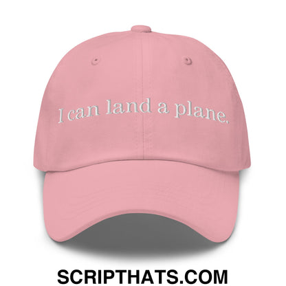 A soft pink unstructured dad hat with white embroidered text i can land a plane perfect for casual wear